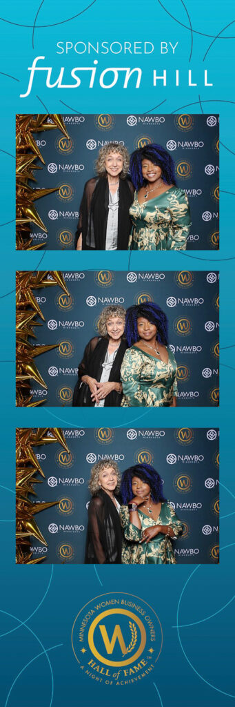 Two women next to step-and-repeat backdrop