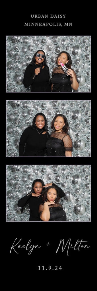 Women next to a disco ball wall